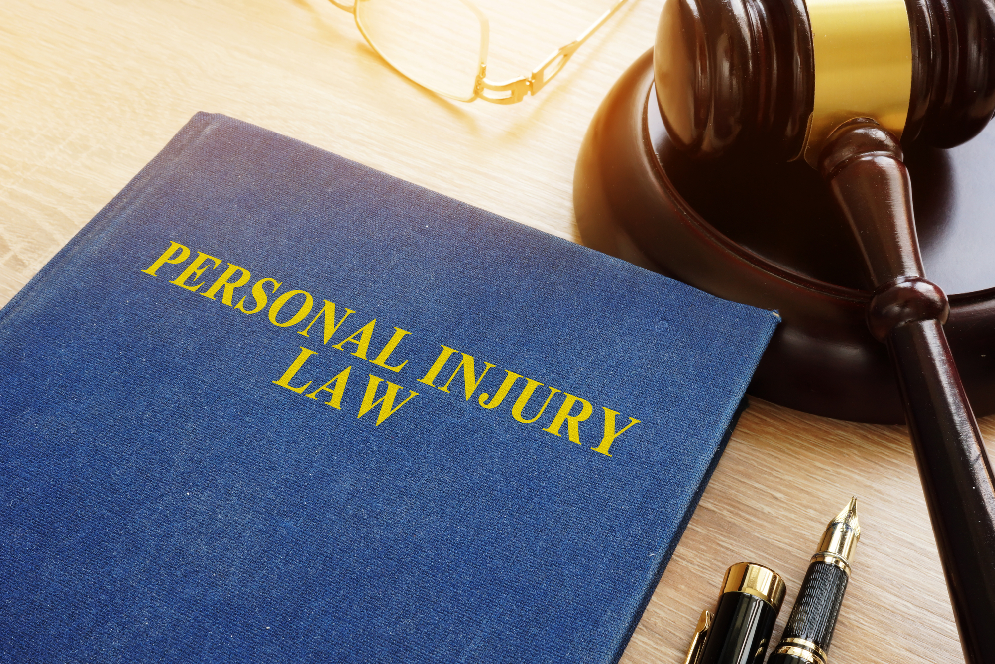 What To Discuss With A Personal Injury Lawyer - Personal injury law on a desk and gavel.